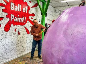 Scott applying a coat to the World's Largest Ball of Paint.